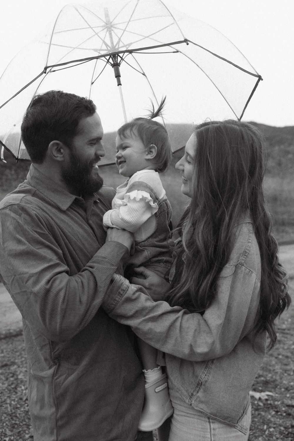 Black and white family portrait of mom, dad, and daughter together