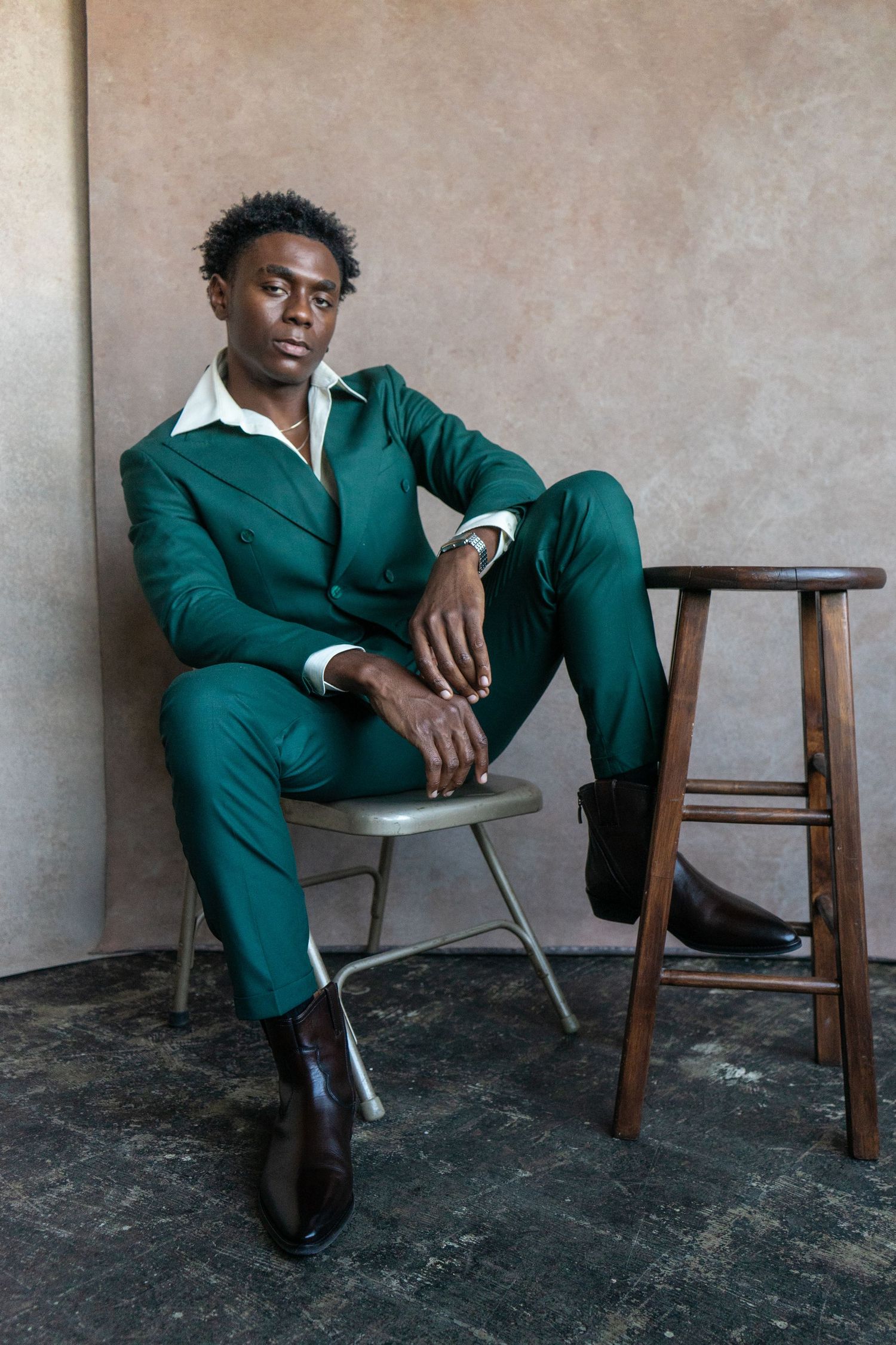 Editorial portrait of a handsome man in a modern green suit.