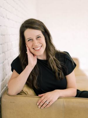 professional branding headshot of a girl smiling on a couch
