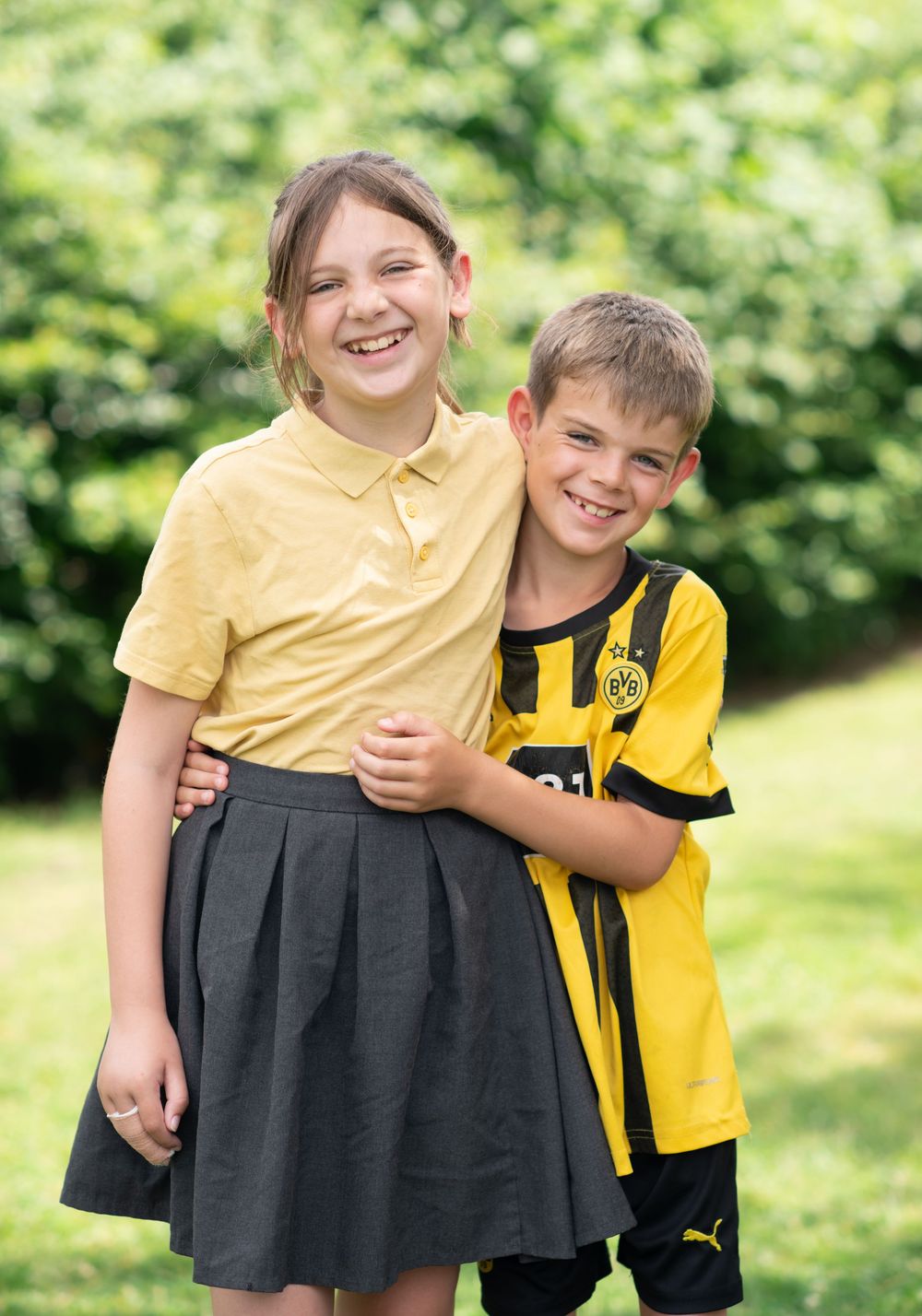 Brother and sister hugging and smiling for school photos