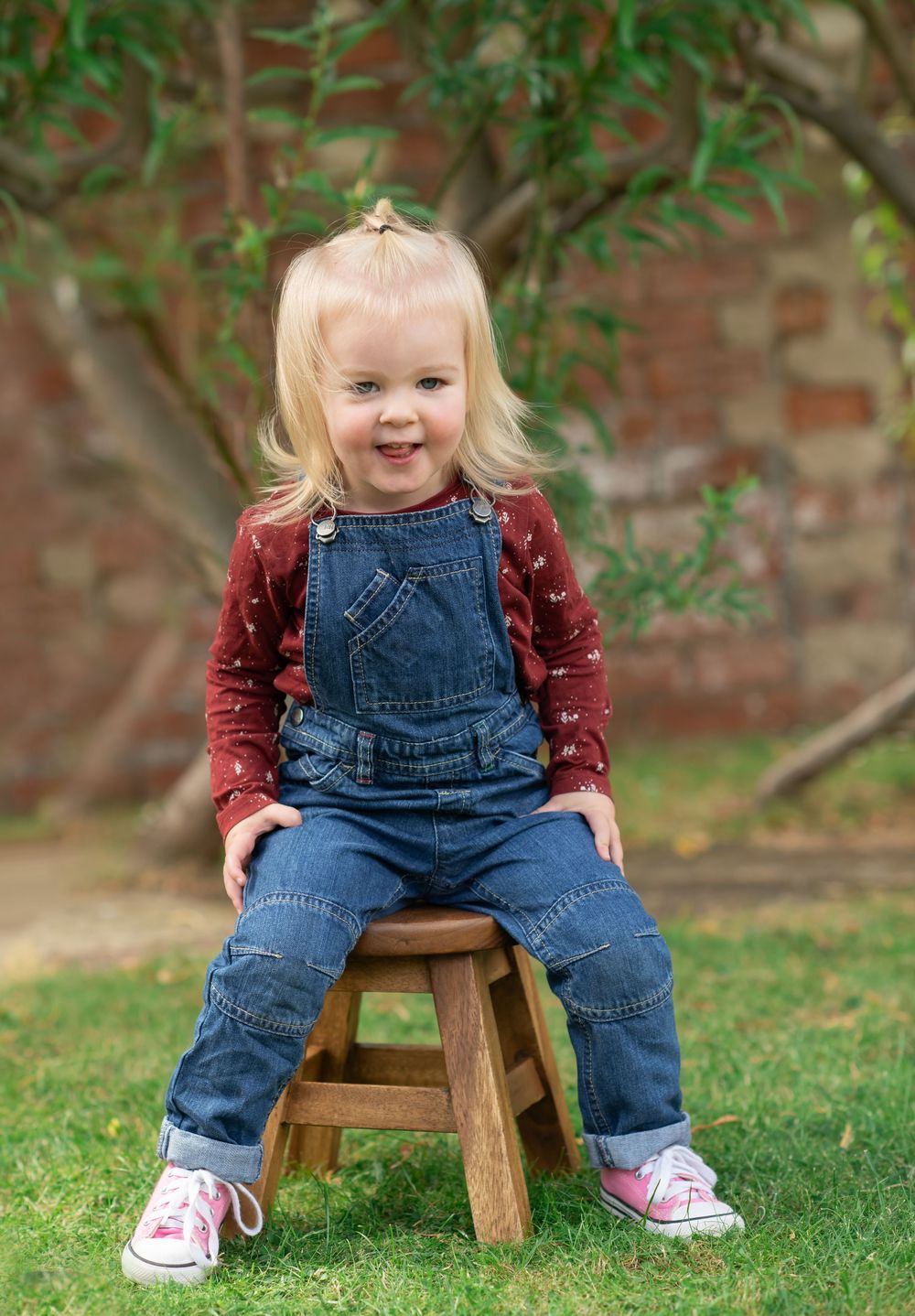 A young girl sat on a stool smiling