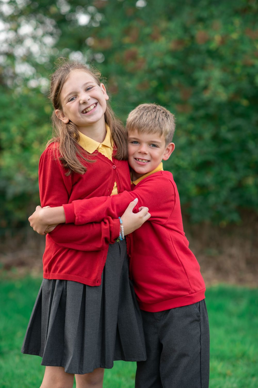Brother and sister hugging on school photo day.