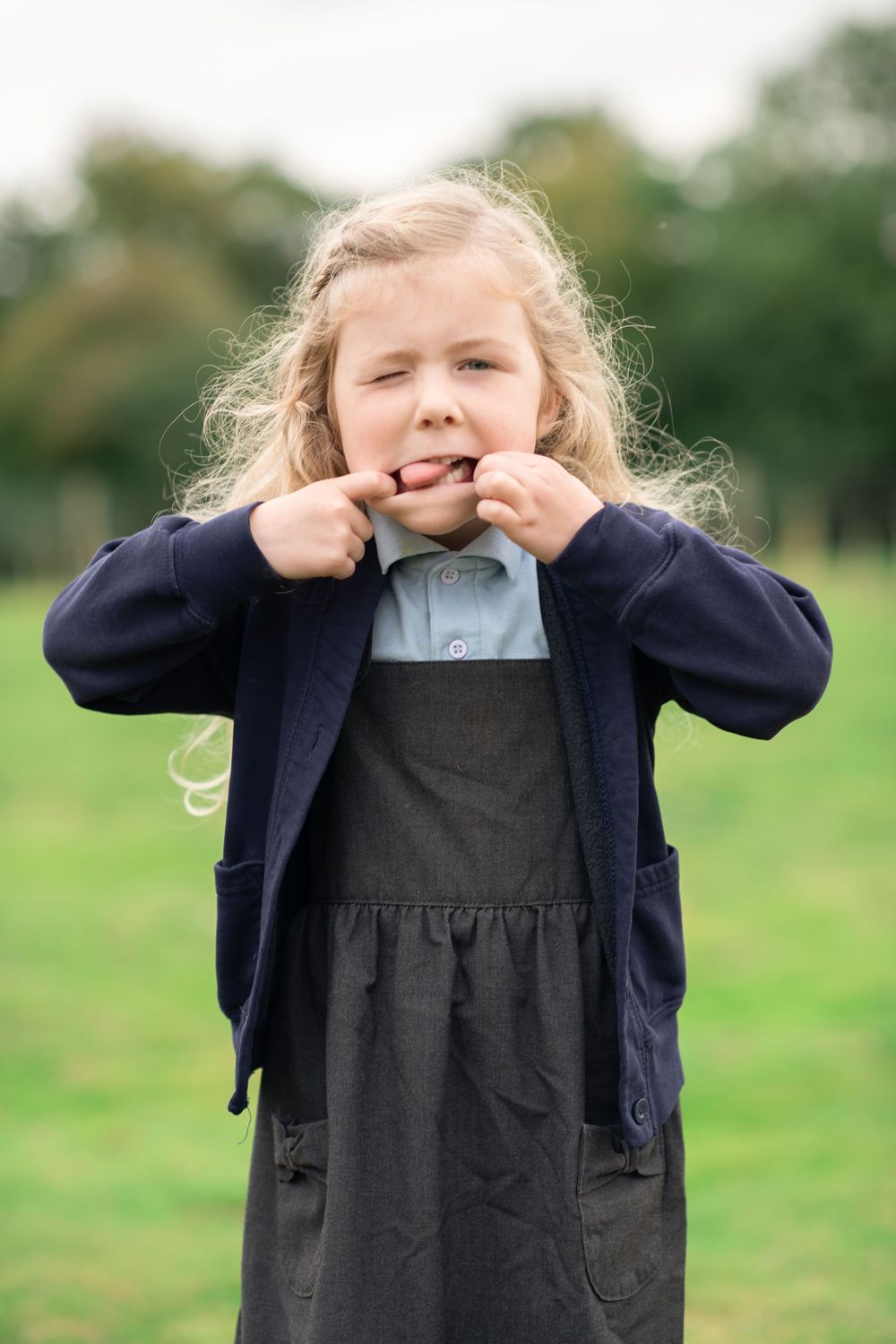 A young girl pulling a funny face at her school photos