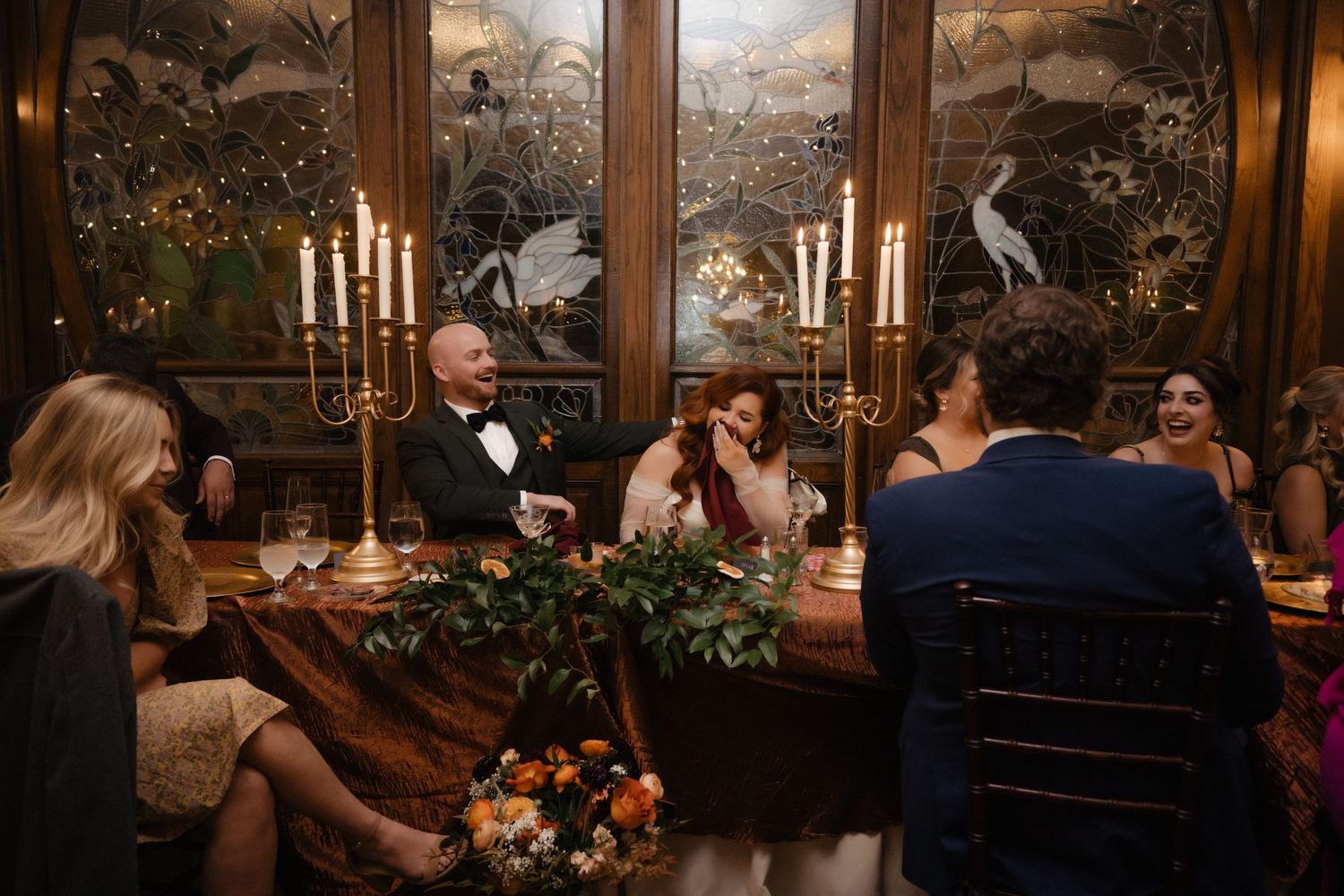 Dimly lit restaurant scene with guests dining at elegant tables.