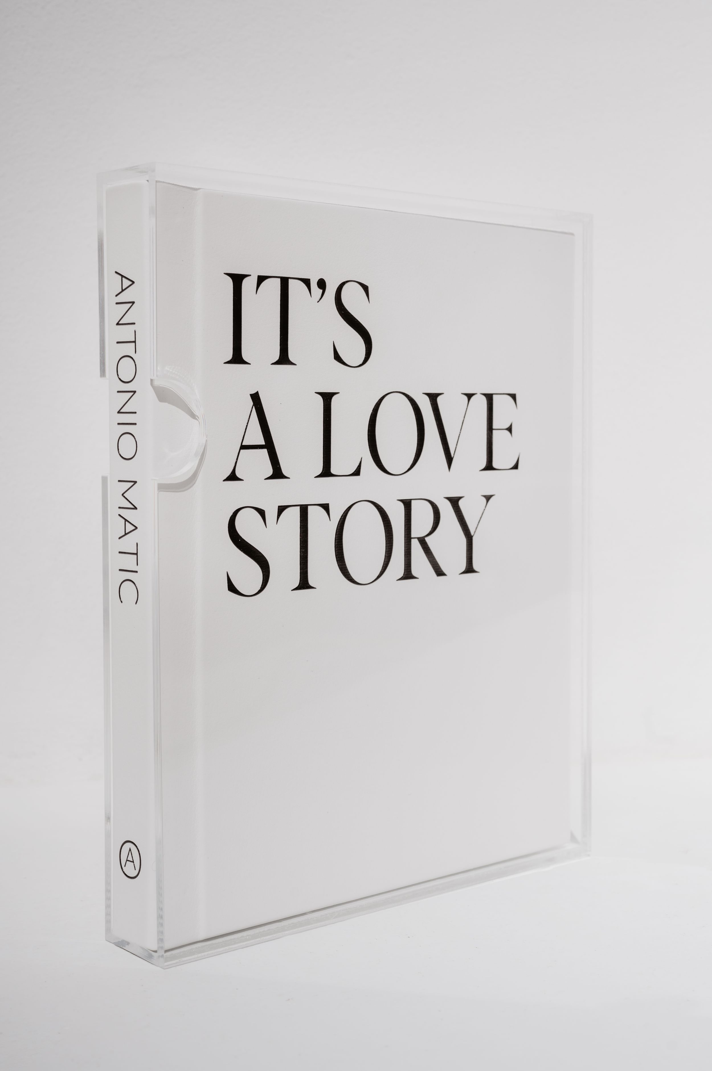 A white hardcover book titled "It's A Love Story" with minimalist design on a plain background.