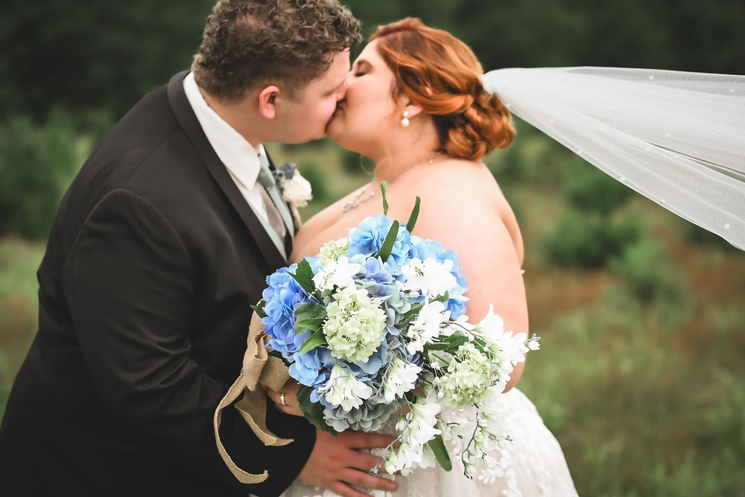 Bride and groom kiss at Cosgray Christmas Tree Farm in Idaville, Indiana.