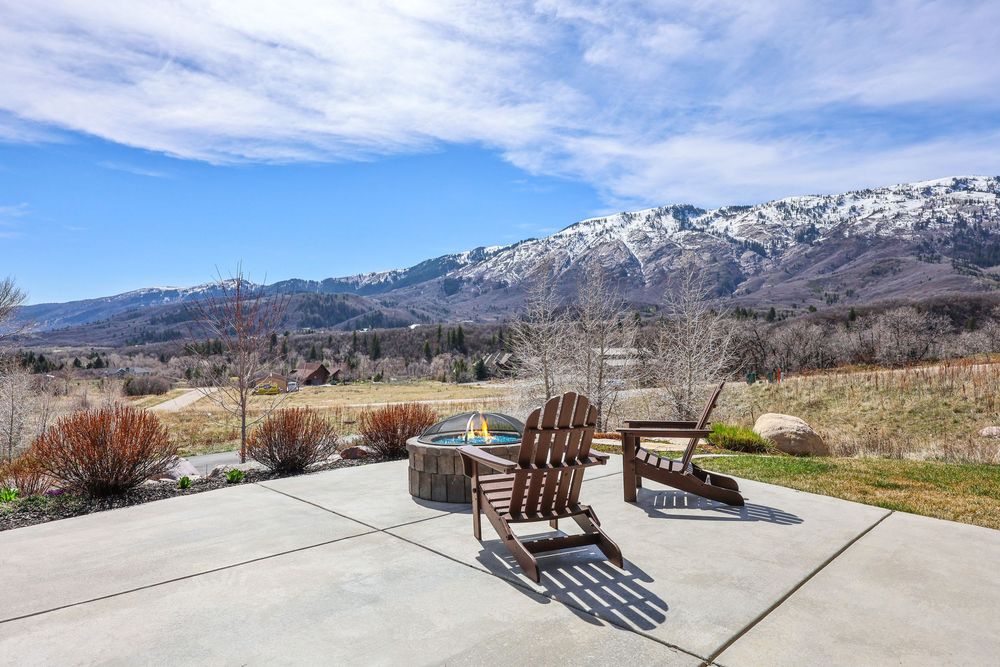 Spacious concrete patio with Adirondack chairs overlooking breathtaking snow-capped Wasatch Mountain range. Captured by Slate Media (best)