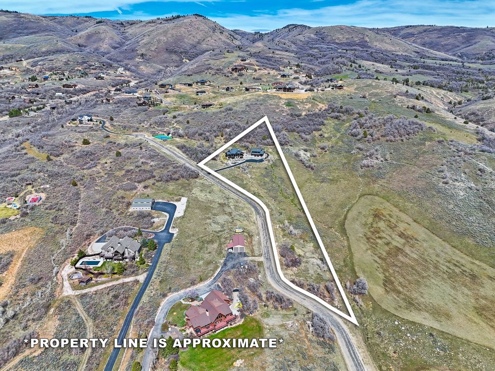 Aerial view of a large vacant land parcel with approximate property lines marked in a hilly area. Captured by Slate Media (best in UT)