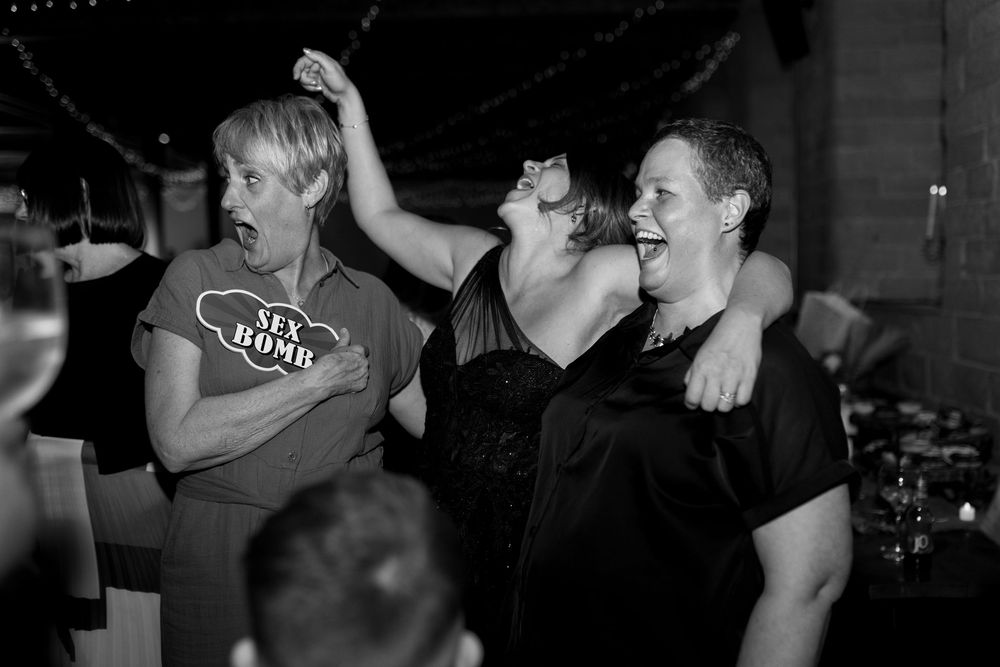 A crowd of people enjoying live music and dancing in a dark venue setting.