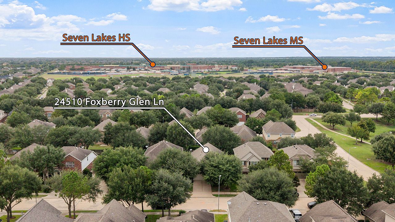 Aerial panoramic view of a residential suburban neighborhood with houses and trees on a sunny day.