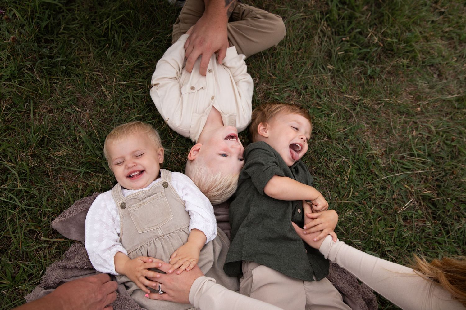 A series of candid photos showing playful moments on grass with children and adults interacting outdoors.