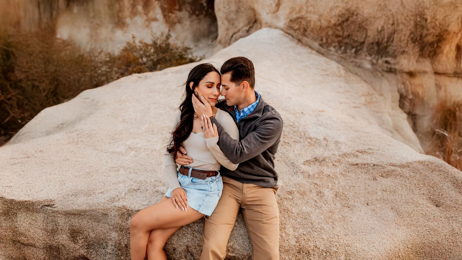 Couple snuggled up on the rock formations of Joshua Tree National Park