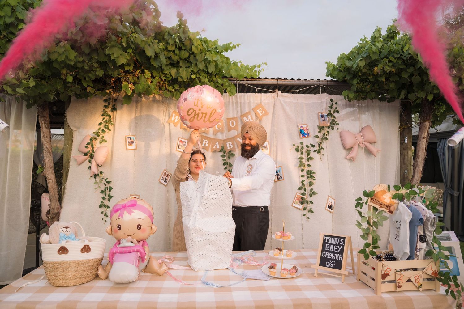 Pink and white themed wedding reception setup with elegant table decorations and floral arrangements in an outdoor venue.