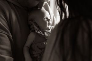 A baby girl looking out the window.