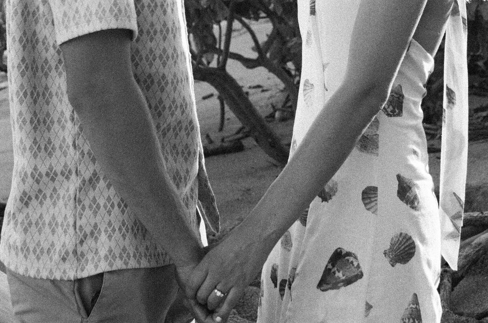 A close-up view holding hands of newly engaged couple during their romantic proposal photo session.