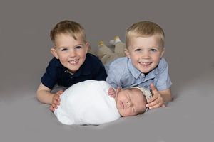 siblings at a gold or silver newborn session