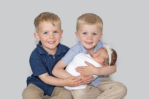 siblings at a gold or silver newborn session