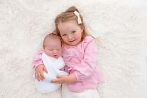 siblings at a gold or silver newborn session