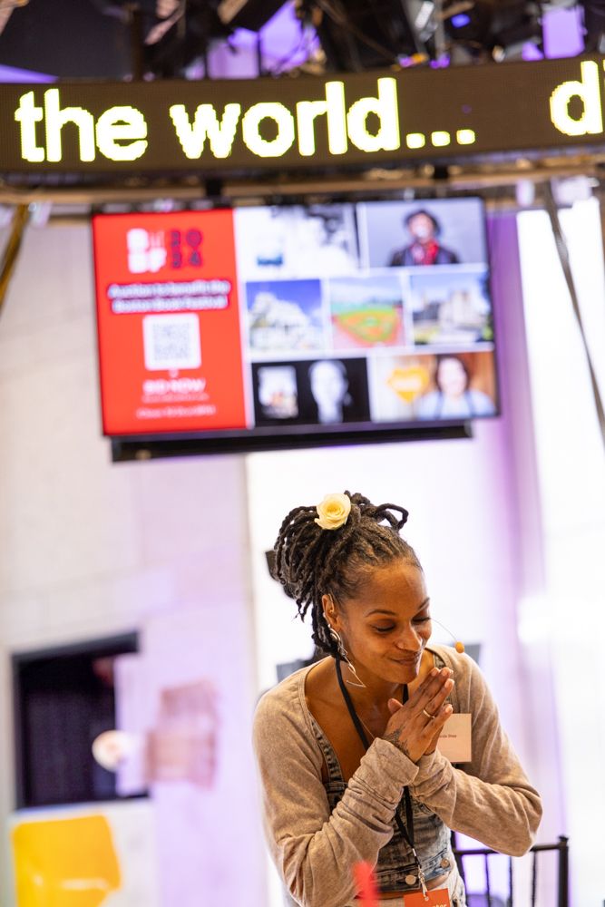 A light-skinned Black woman bows with eyes closed and hands pressed together