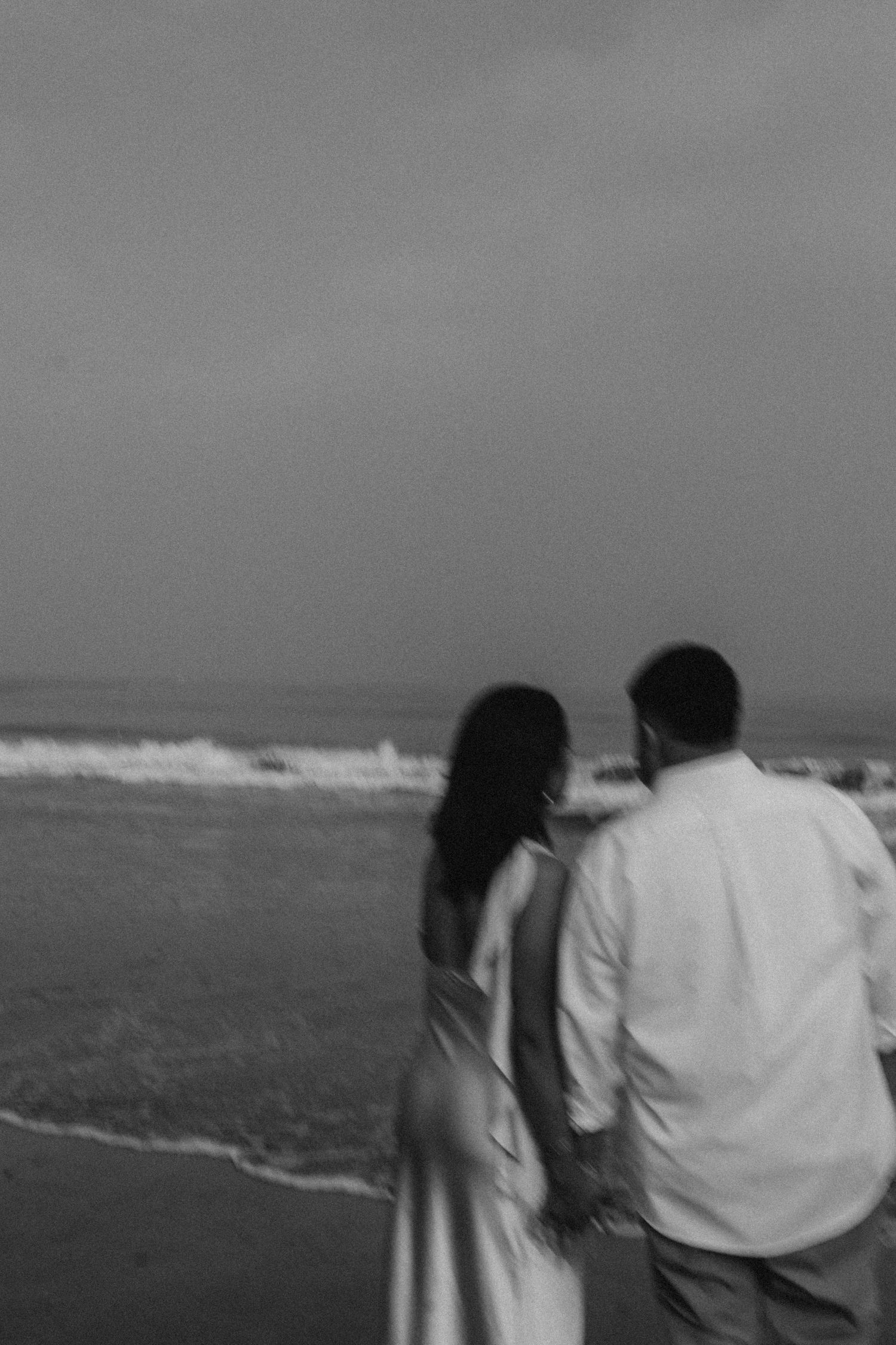 Black and white photo of a couple sharing a quiet moment, blurred and grainy for a timeless feel.