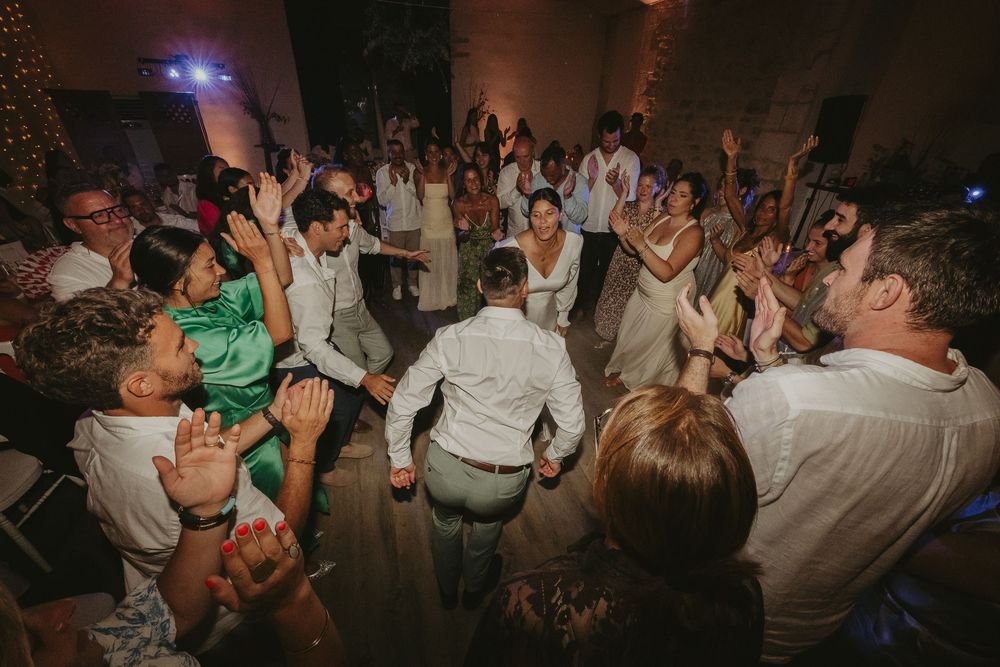 Invités dansant bras levés sur la piste de danse pendant la soirée de mariage
