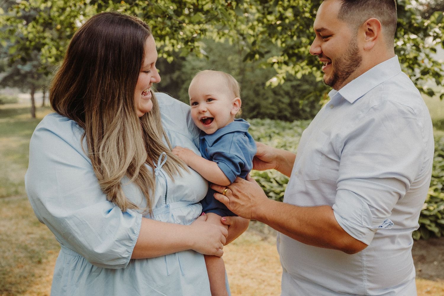 Black and white family portrait in wooded setting during maternity photoshoot.