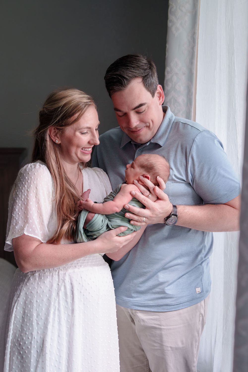 mom Dad love newborn baby by the window natural light mom love cuddles candid posed black and white baby boy Dallas Texas big brother