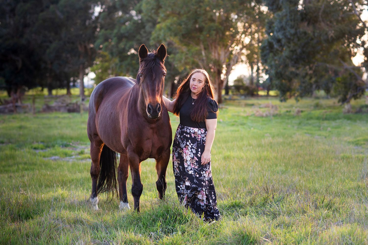 Woman and horse standing in a paddock together during a pet photo session in Perth