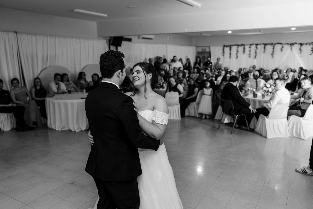 Black and white photo of bride and groom sharing their first dance at a wedding reception.