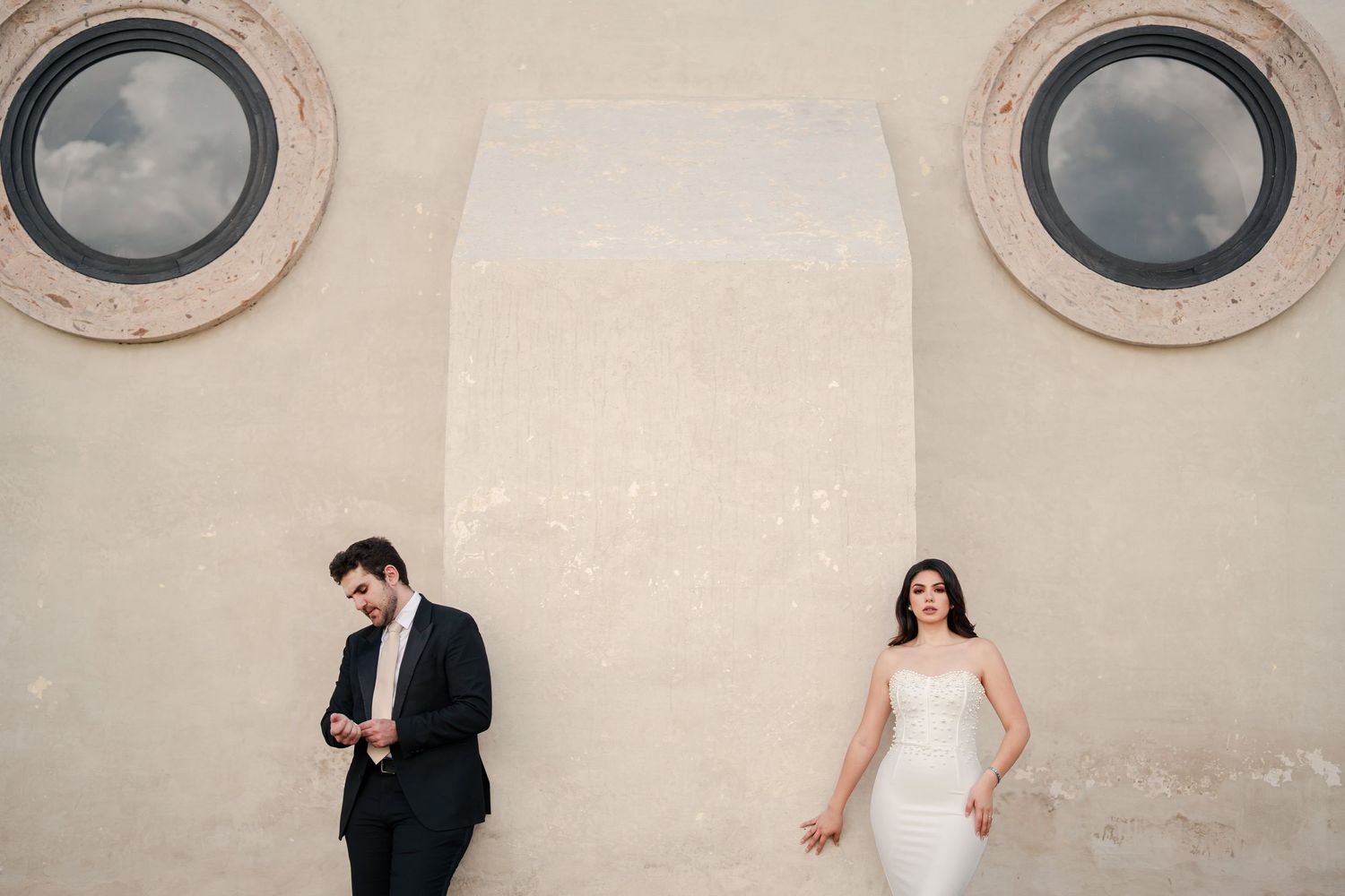 Elegant wedding portrait in classic white room with ornate furniture and chandelier.