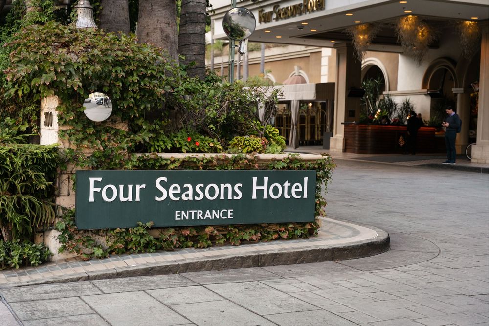 Four Seasons Hotel entrance sign surrounded by lush greenery and elegant architecture at a luxury resort.