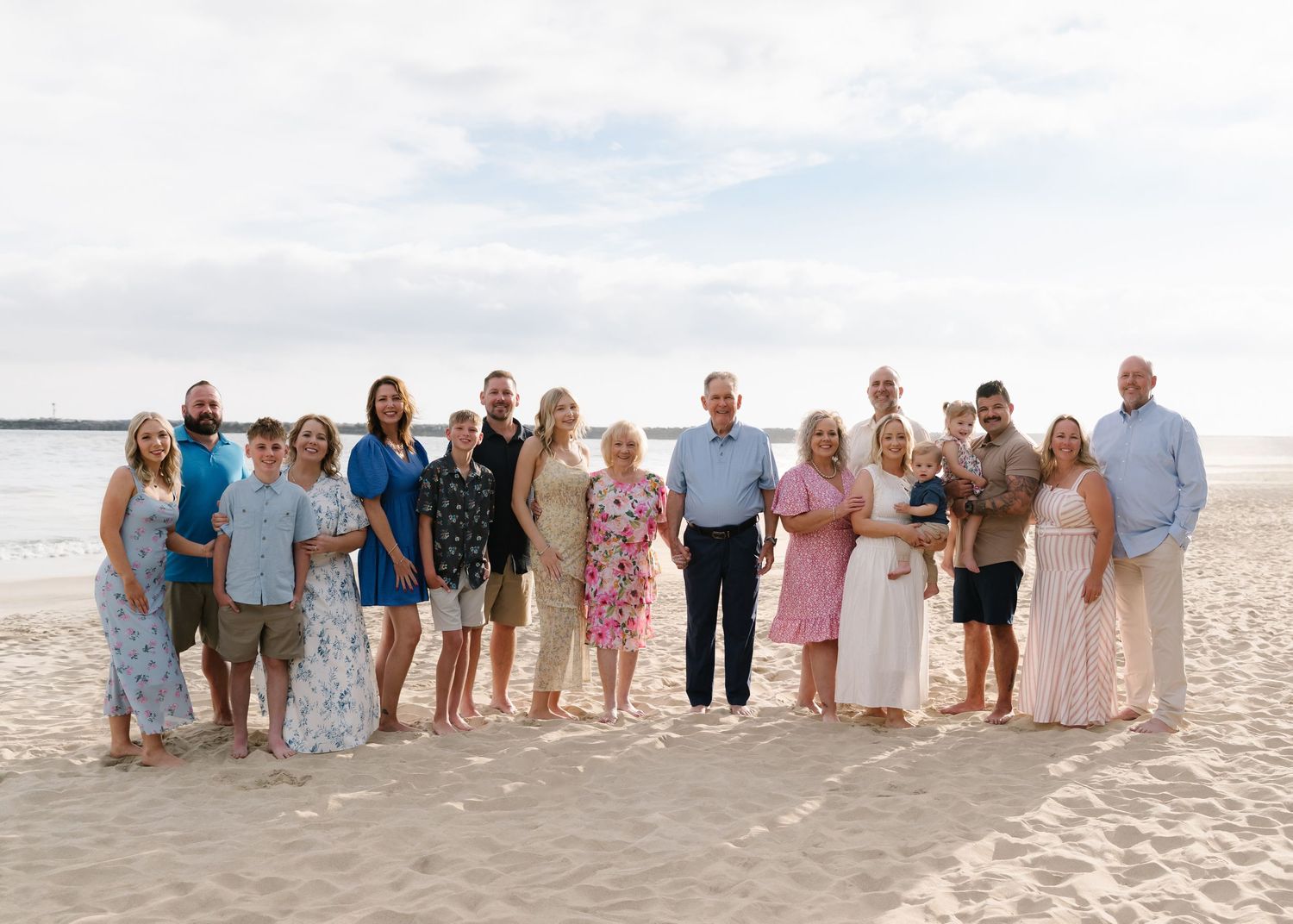 Large extended family gathered together on the beach in Newport Beach for a multigenerational family portrait.