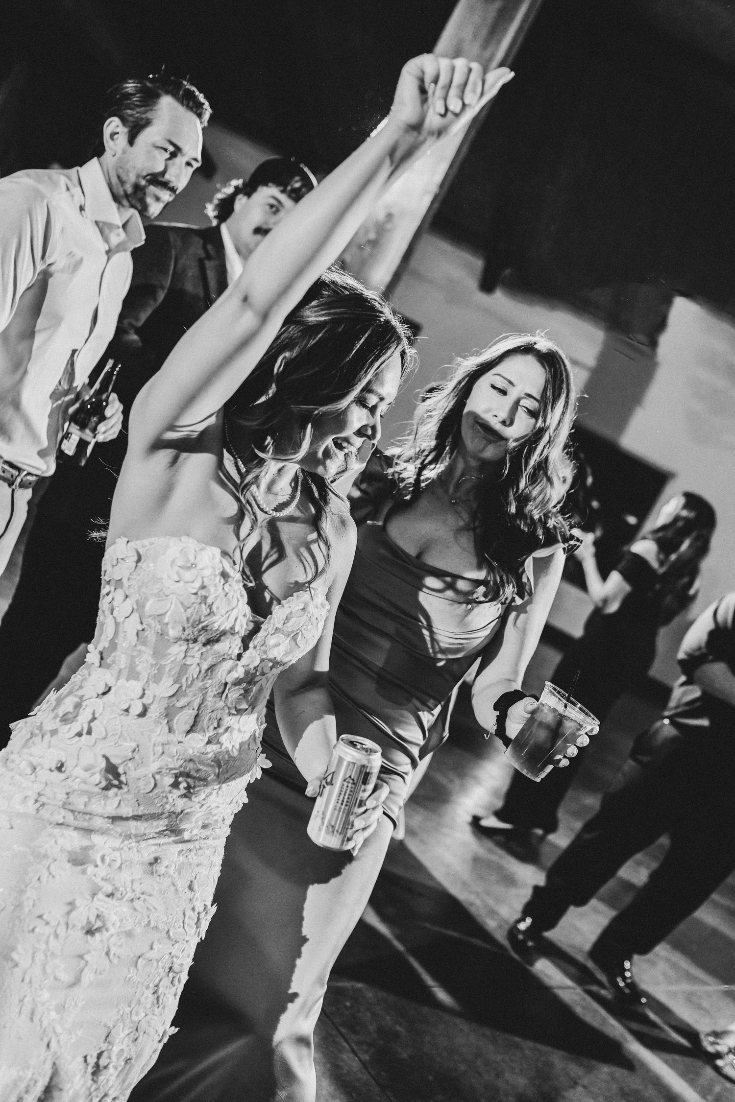 Bride and groom dancing beneath glowing Edison lights