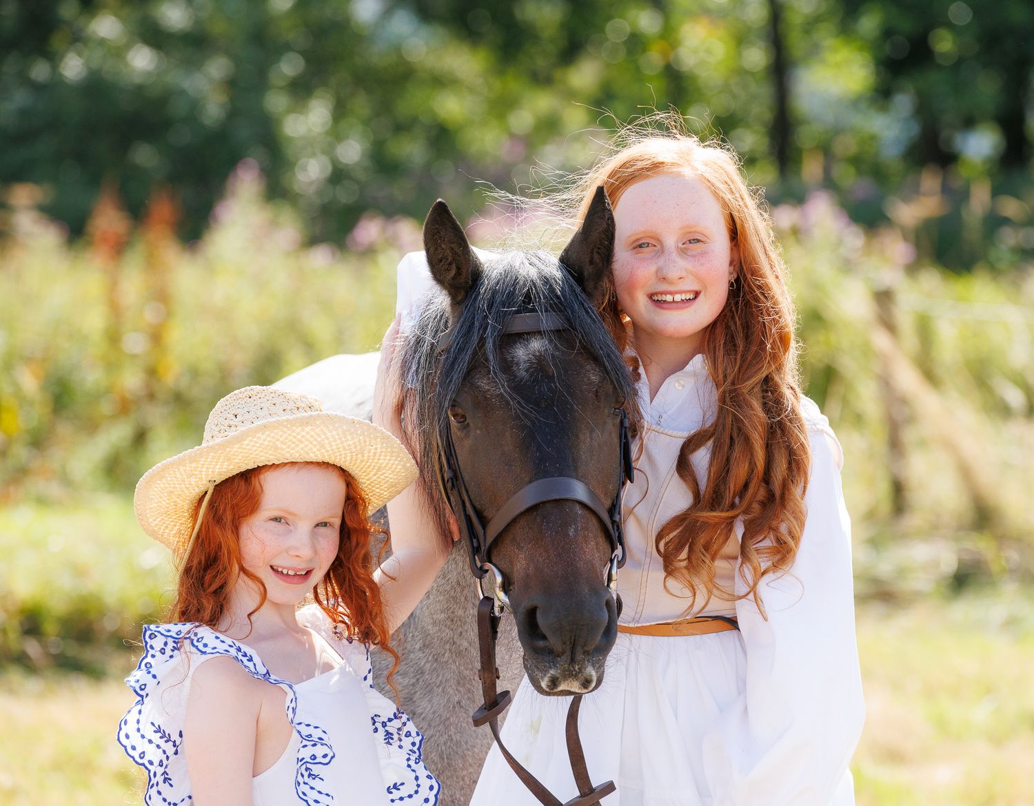 A horse and its rider enjoy an outdoor photoshoot session near rustic wooden fencing on a sunny day.