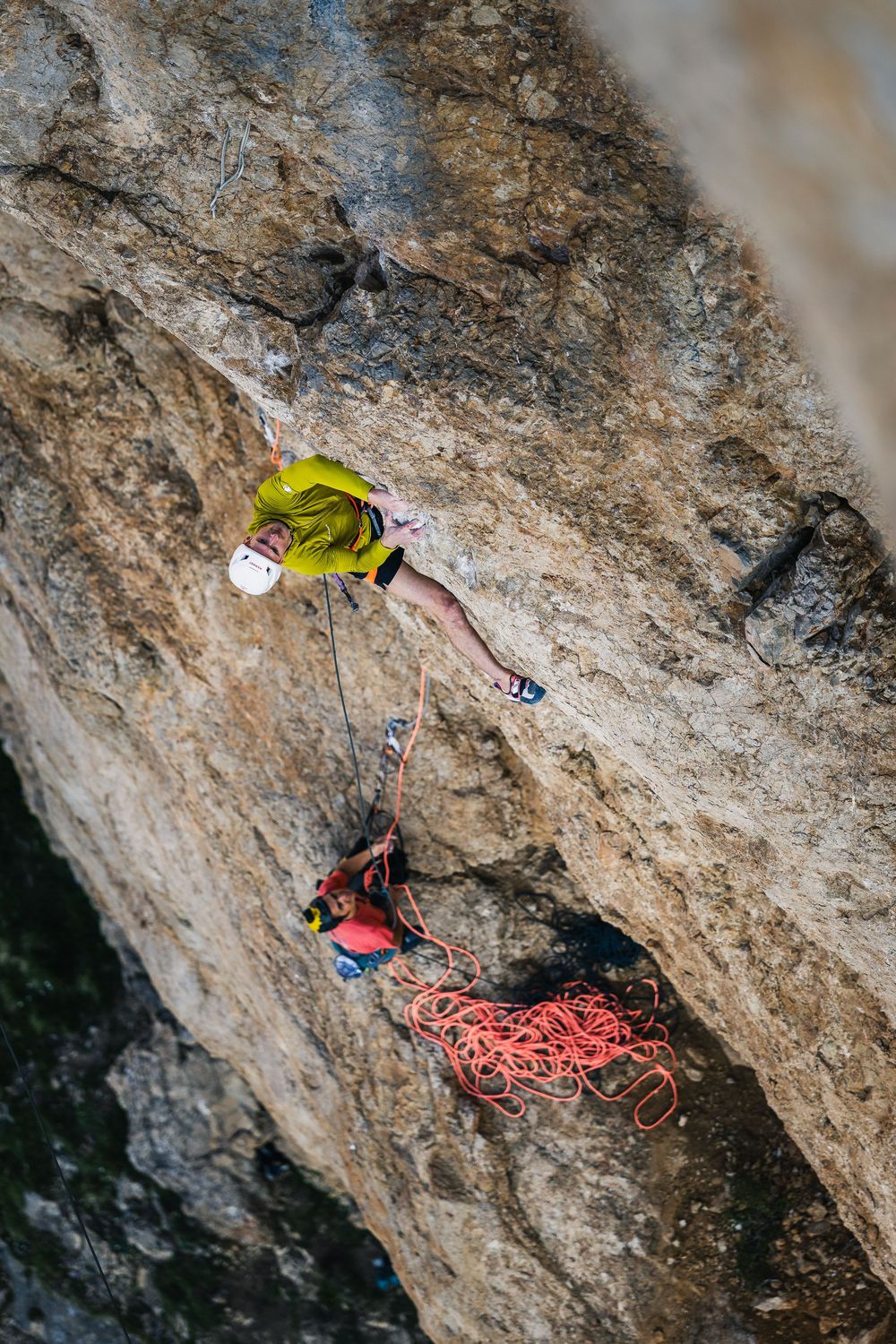 Adam Ondra in a yellow top and white helmet on a steep yellow wall of Egoland, Marmolada. Photo: Jan Virt