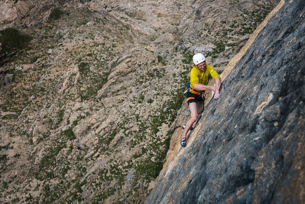 Adam Ondra in a yellow top climbing steep orange limestone on Egoland, Marmolada South Face. Photo: Jan Virt