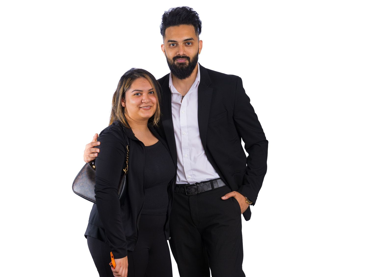 Professional portrait of a bearded man with styled dark hair, wearing a black blazer over a white collared shirt against a white background.