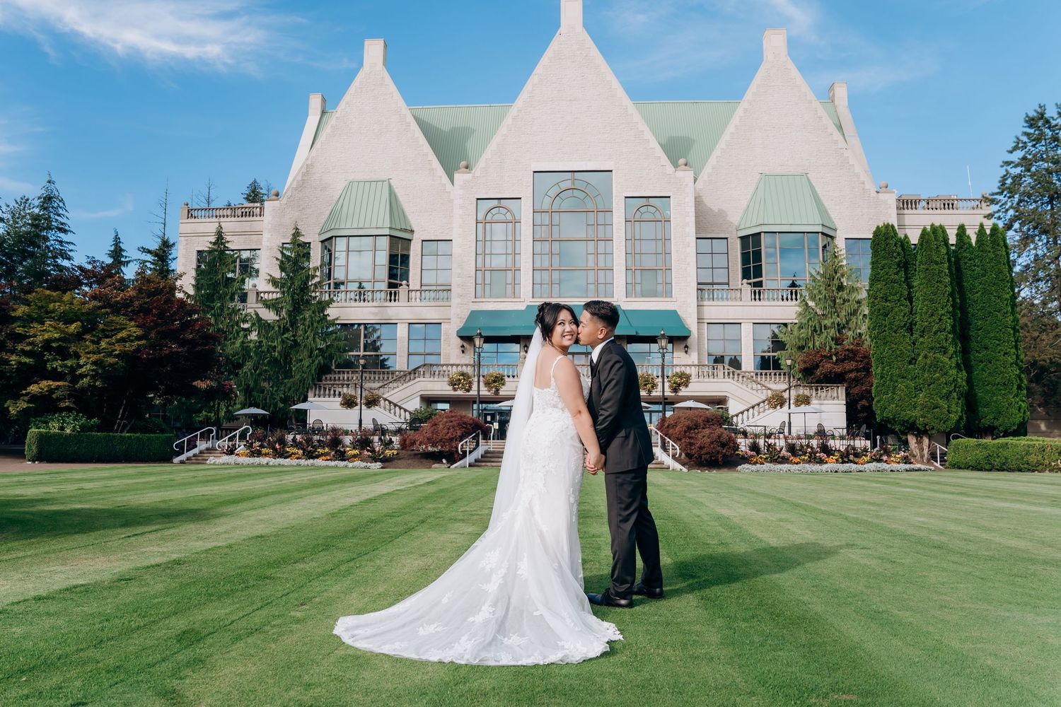 Bride and groom embracing on a paved path among trees at Swaneset Bay, with warm sunset light over the golf course.