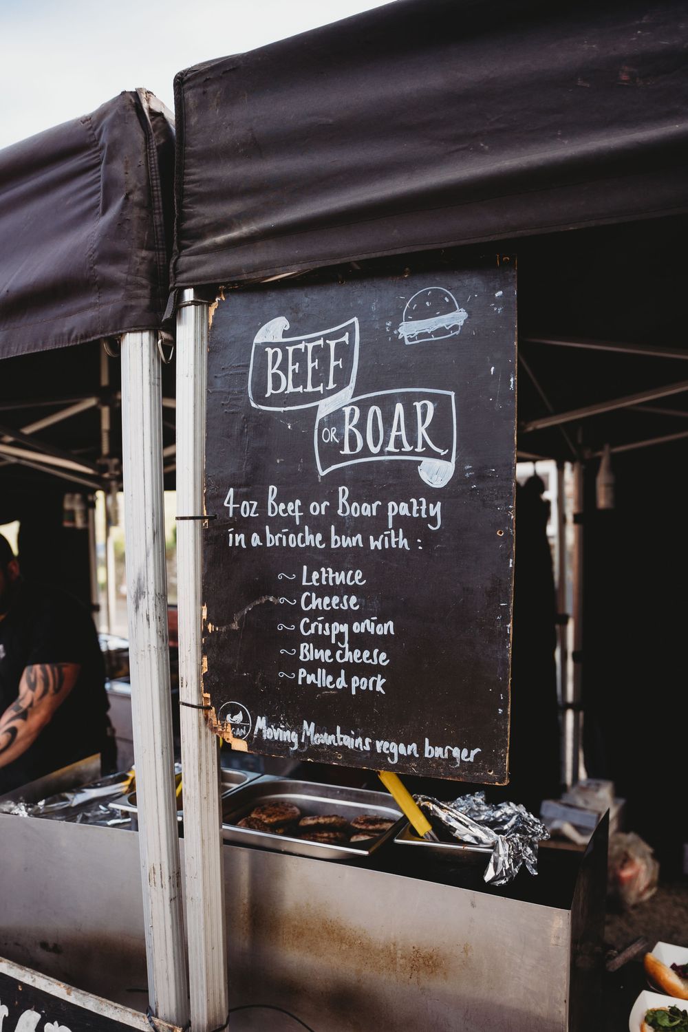Beef or Boar food truck chalkboard menu sign offering 4oz patties in brioche buns with toppings.