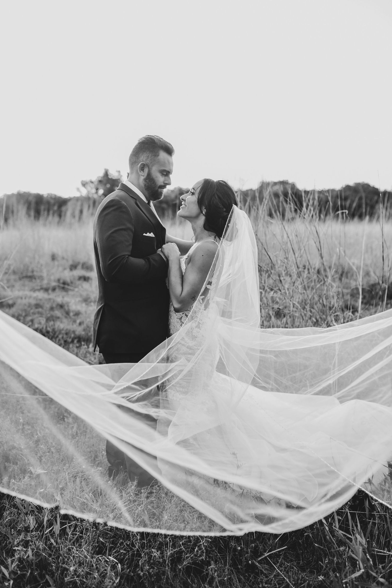 black and white photo of bride and groom in field in corinth texas