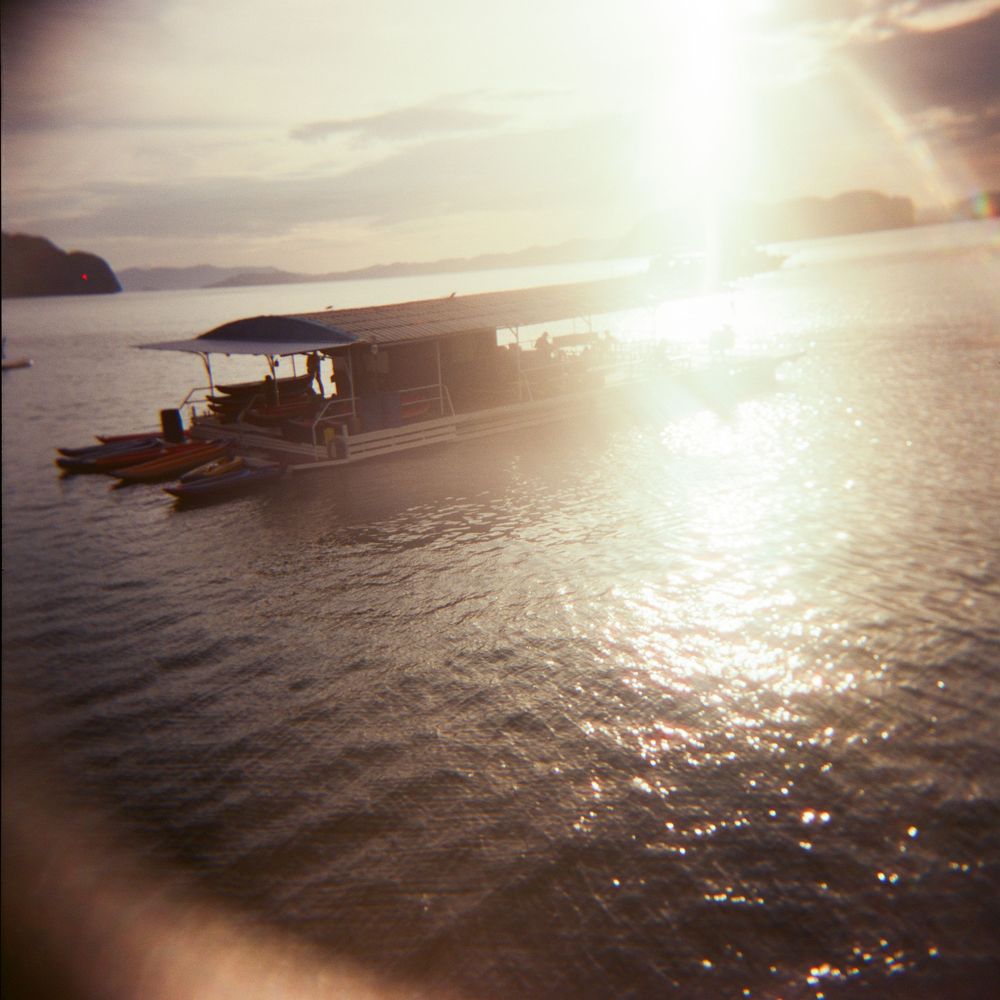 Dramatic sunset over ocean waters with sun reflection creating sparkles on the surface.