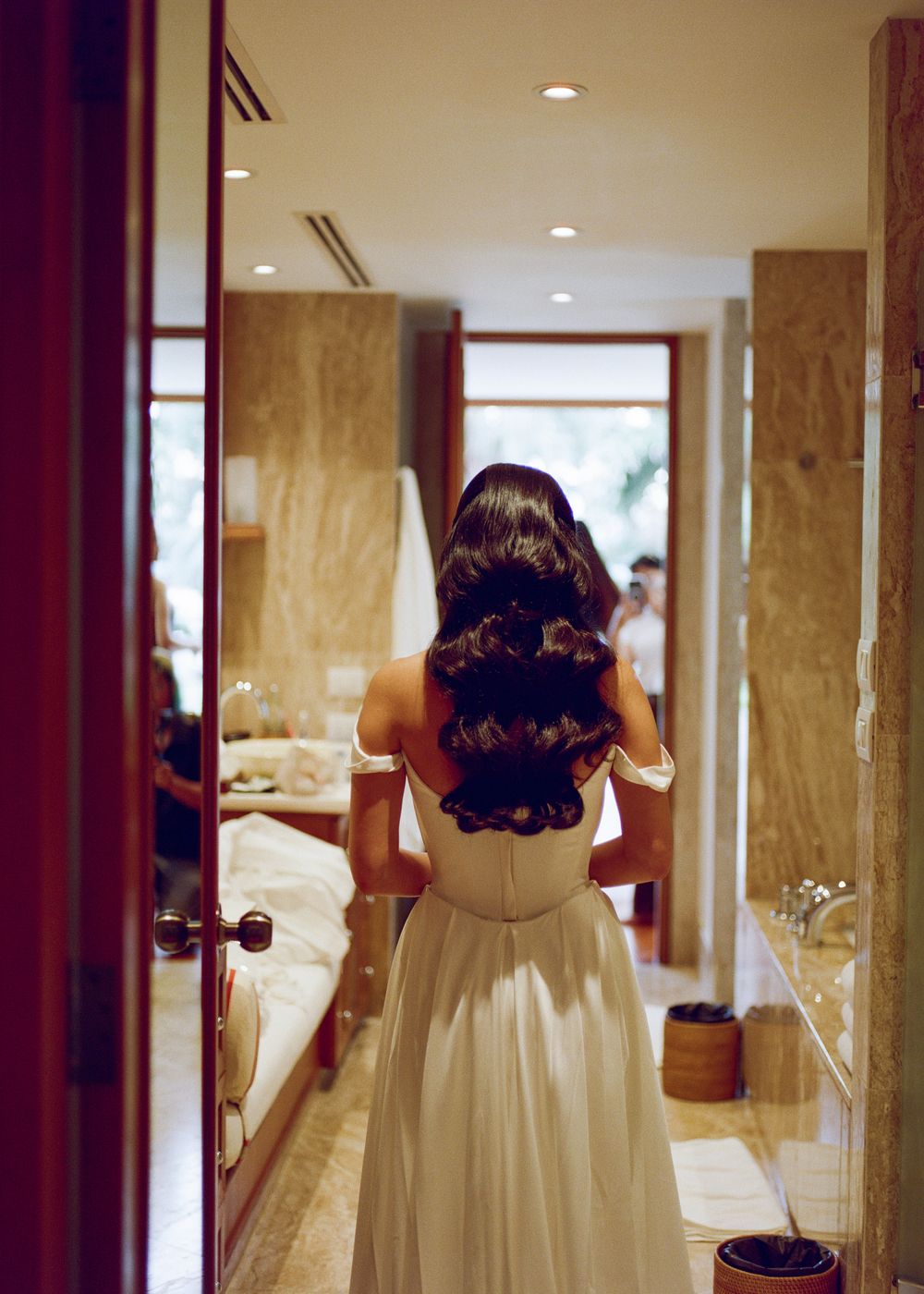 Elegant white wedding dress details shown in a series of mirror reflections in a luxurious dressing room.