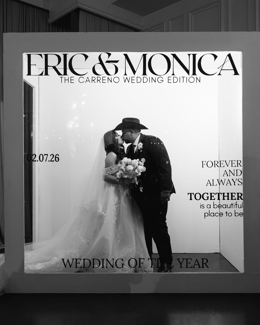 Black and white wedding photo of Eric and Monica Carreno kissing, bride in white gown holding bouquet, groom in dark suit.