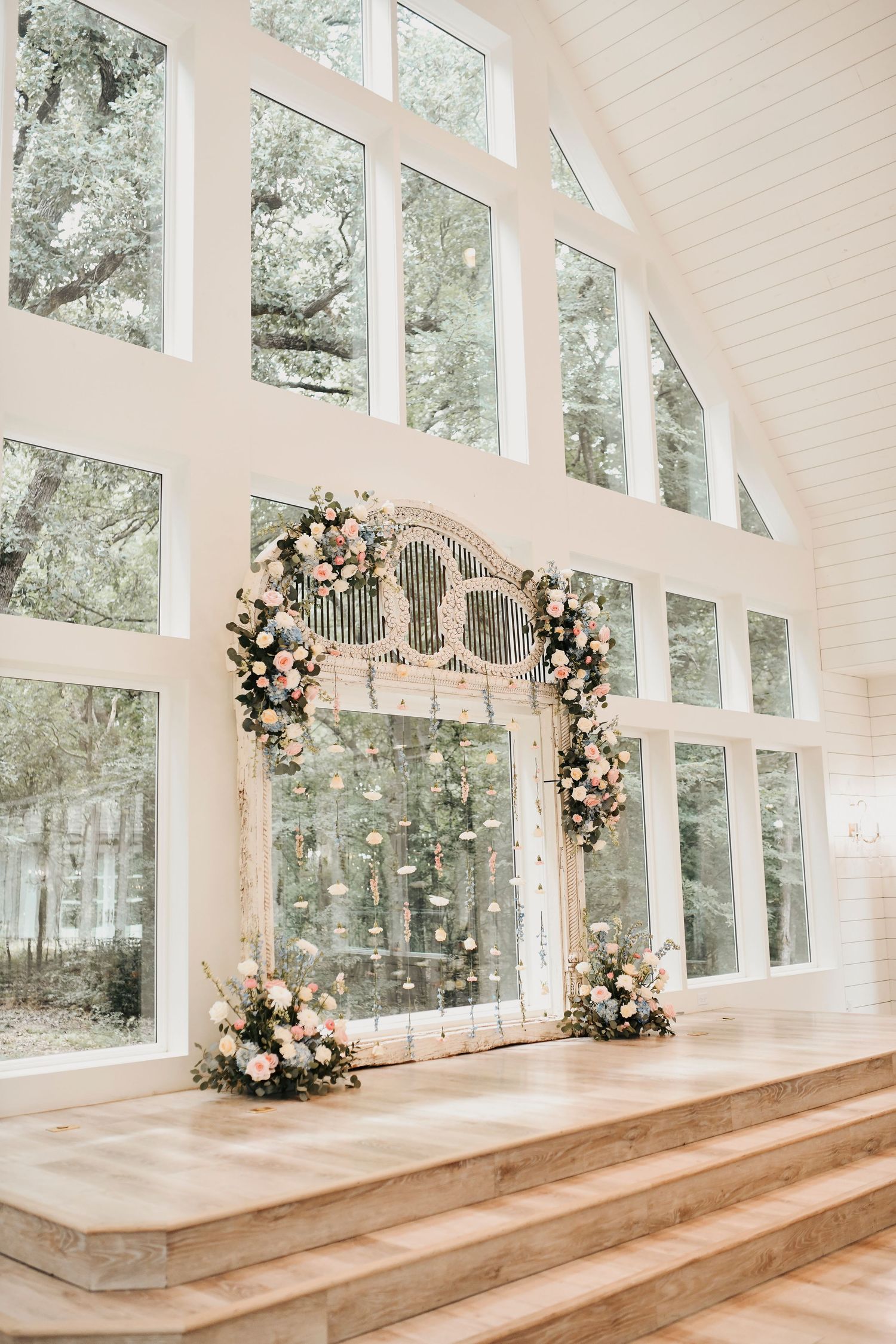 Light-filled wedding ceremony space at The French Farmhouse with exposed wood beams and white chairs