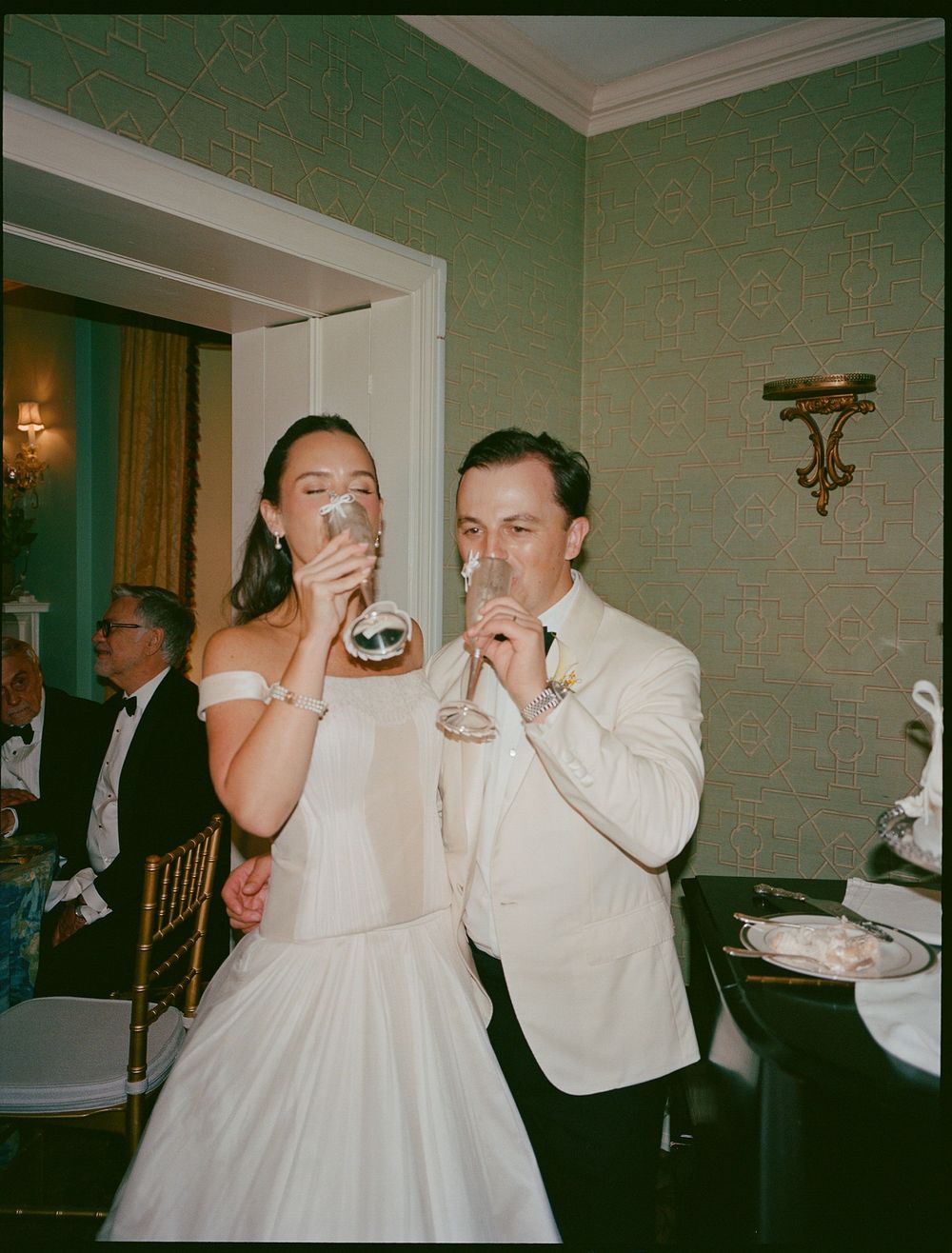 Bride and groom toasting with champagne glasses at their elegant wedding reception venue.