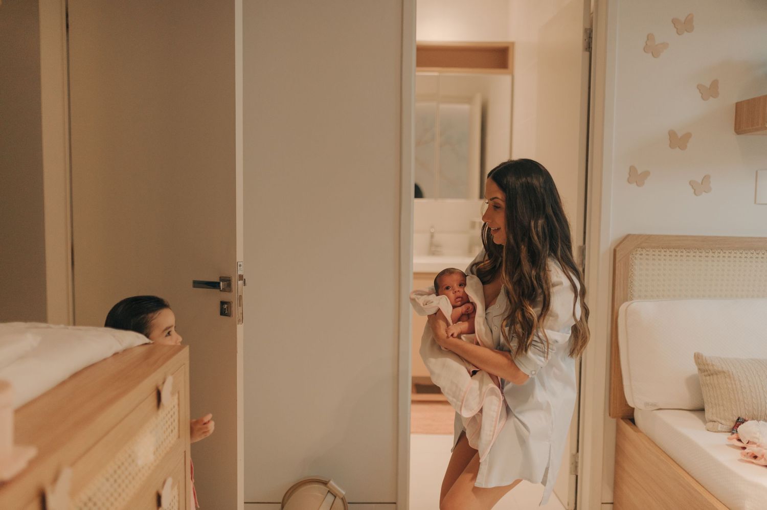 A quiet nursery moment showing gentle interaction with a small infant in warm ambient lighting.