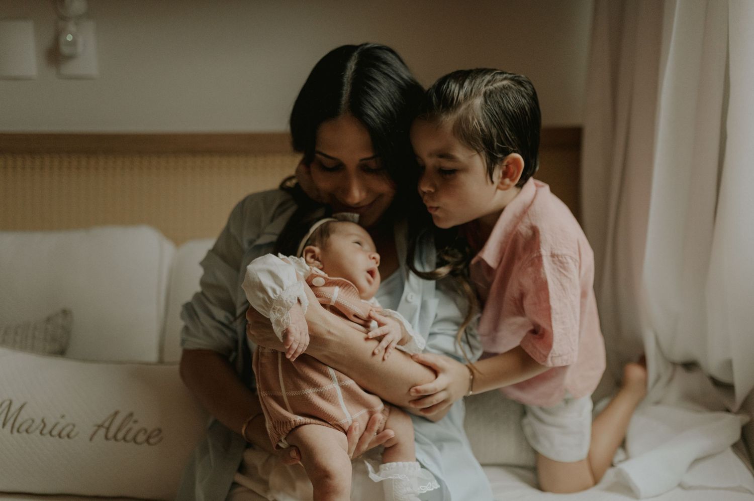 Intimate family moment with newborn baby in a softly lit room.