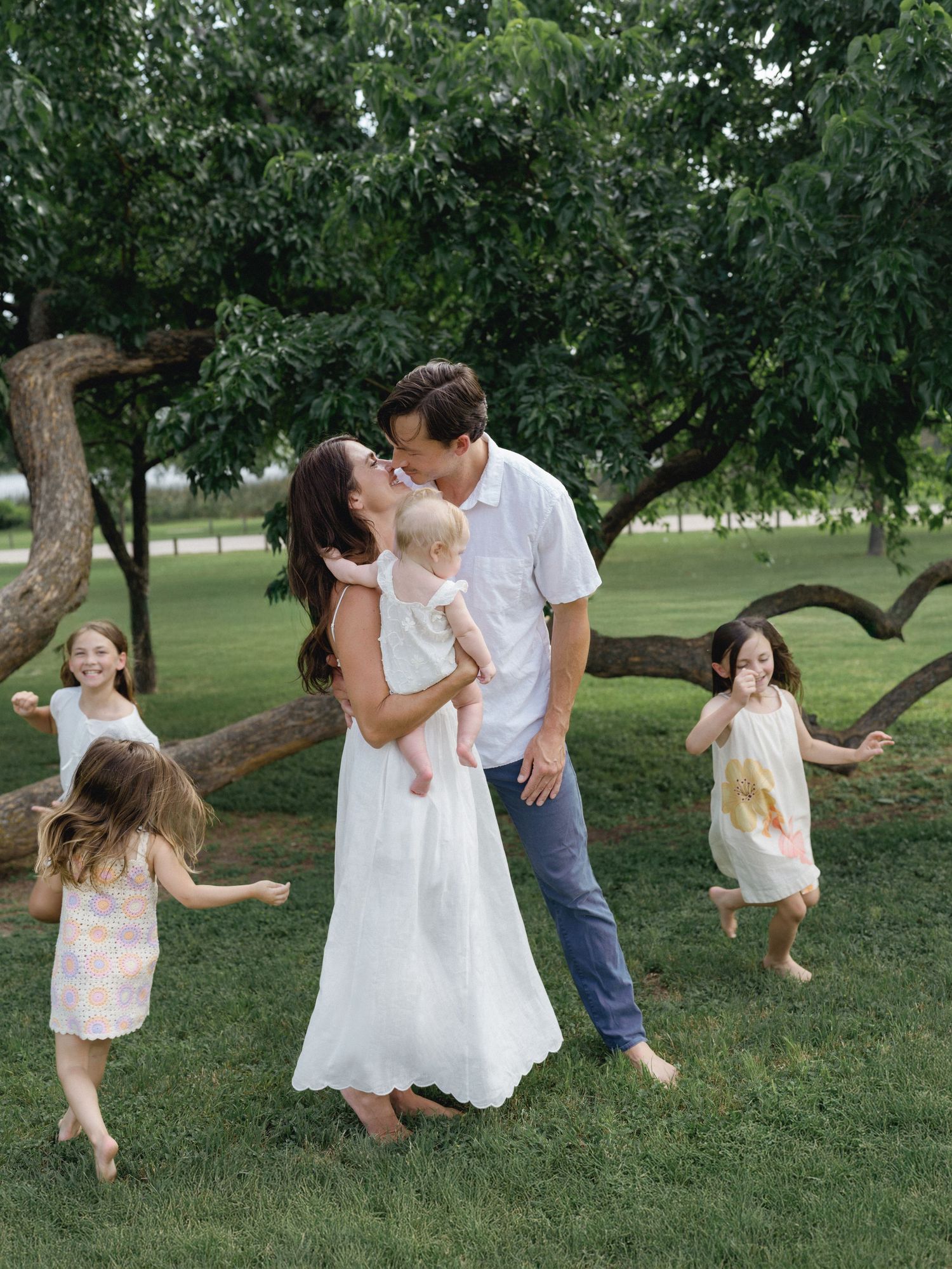 Family playing with their young children in a grassy Dallas park