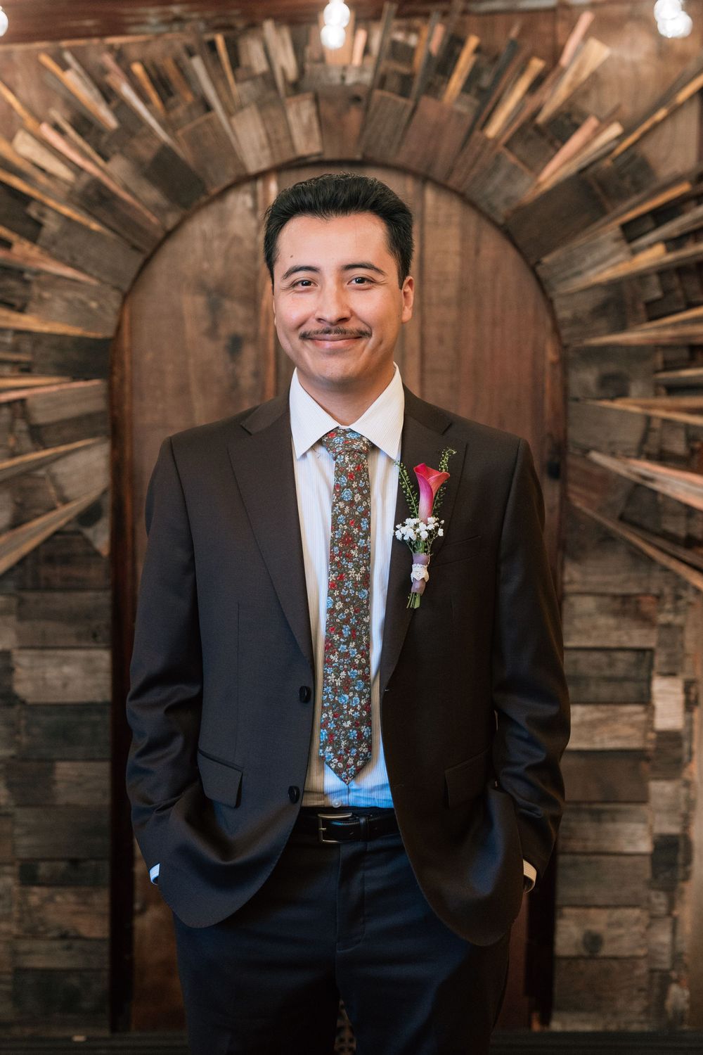 film wedding photography image of groom standing in front of art deco piece