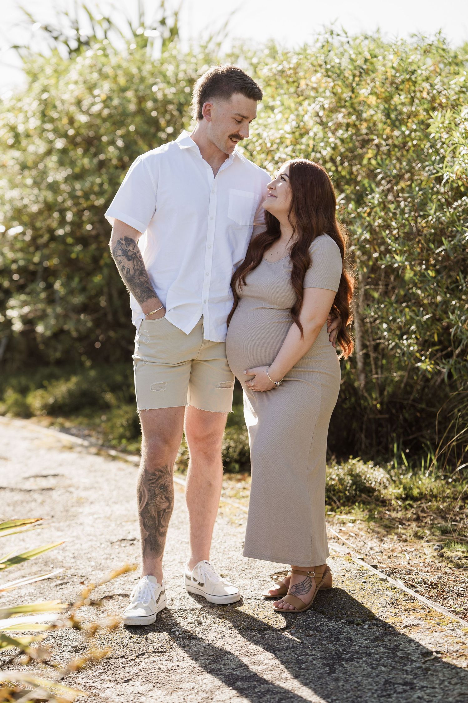 pregnant woman embracing belly backlit